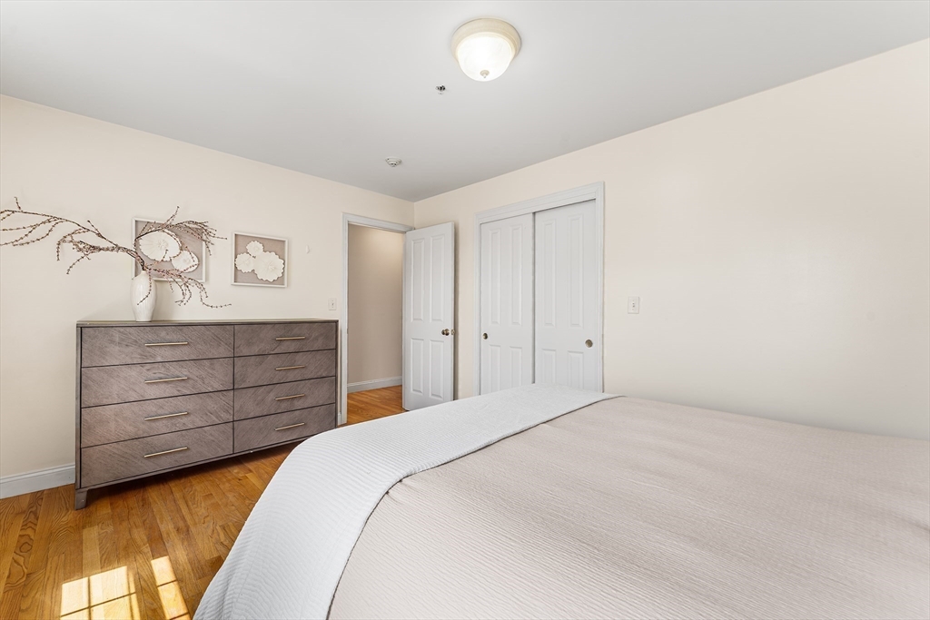 30 Russell Street, Unit 5 Waltham, MA 02453 - Photo 18 of 26 a bedroom with a bed and a dresser