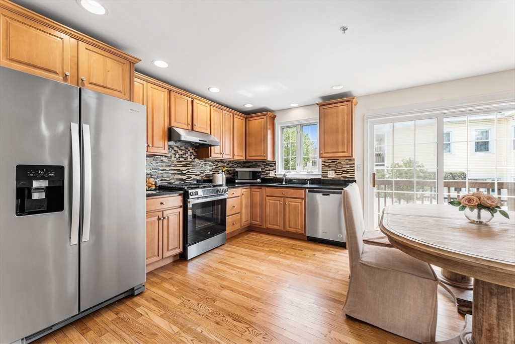30 Russell Street, Unit 5 Waltham, MA 02453 - Photo 8 of 26 a kitchen with stainless steel appliances granite countertop a refrigerator a sink and a stove