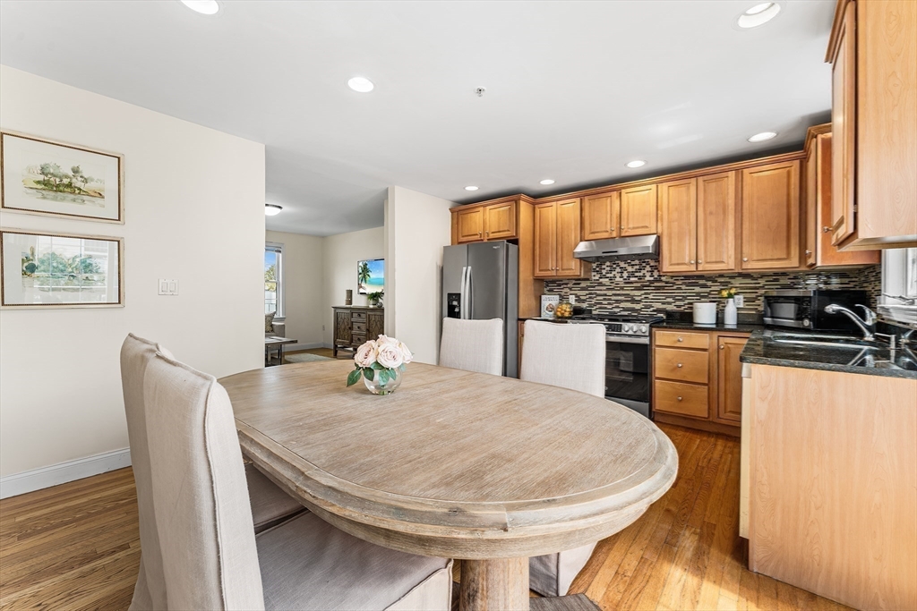 30 Russell Street, Unit 5 Waltham, MA 02453 - Photo 10 of 26 a kitchen with a table chairs and wooden floor