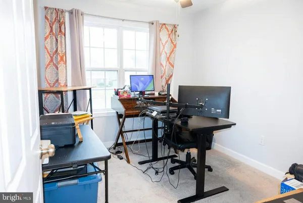 a view of a workspace with furniture and a window
