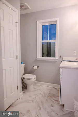 a bathroom with a toilet and a window