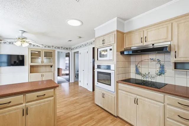 a kitchen with stainless steel appliances granite countertop a refrigerator and a stove top oven