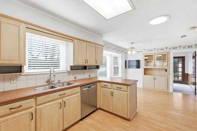 a kitchen with cabinets wooden floor and a sink