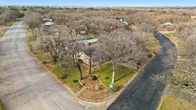 an aerial view of a house with a yard and lake view