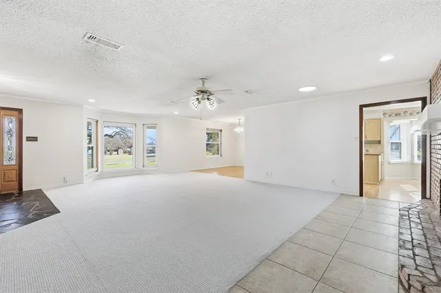 a view of an empty room with window and cabinet