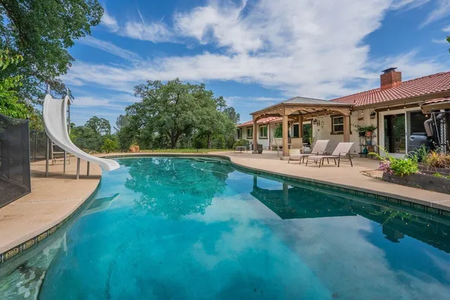 swimming pool view with a seating space and a garden