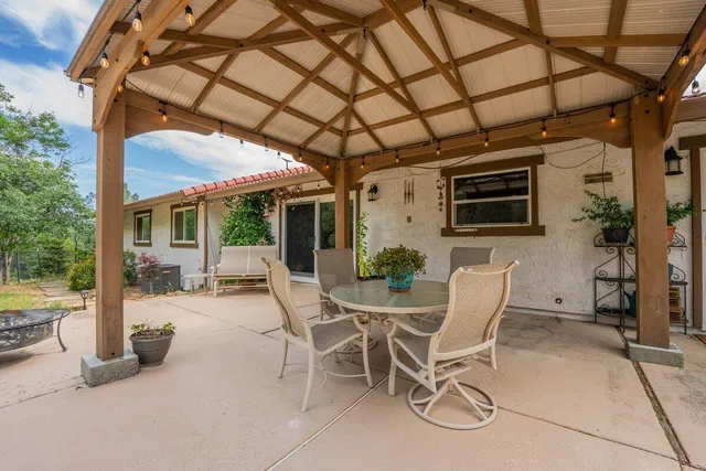 a view of a patio with table and chairs and potted plants
