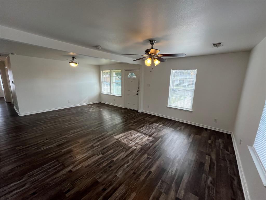 1107 Calle Real Mesquite, TX 75149 - Photo 5 of 24 an empty room with wooden floor chandelier fan and windows