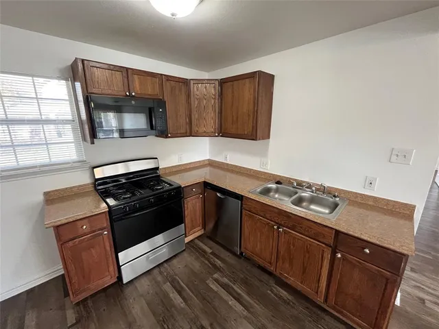 a kitchen with wooden cabinets and stainless steel appliances