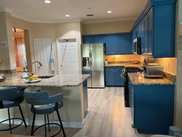 a kitchen with a table chairs refrigerator and microwave