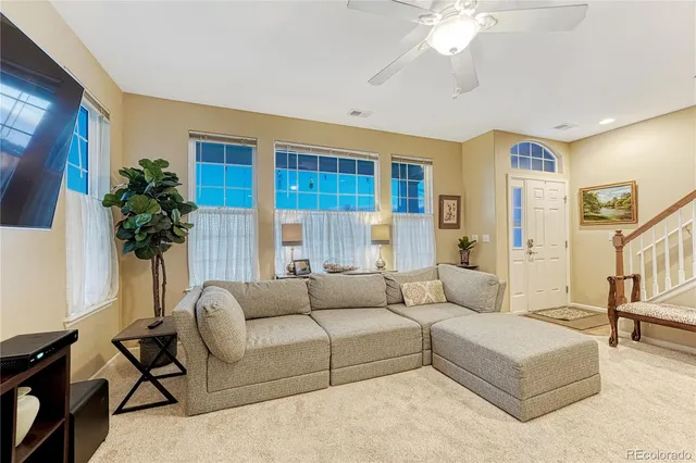 a living room with furniture and a potted plant