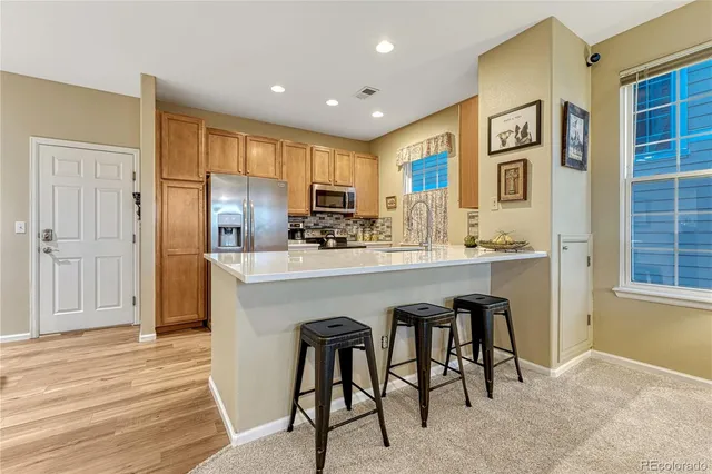 a kitchen with stainless steel appliances granite countertop a refrigerator and a stove top oven