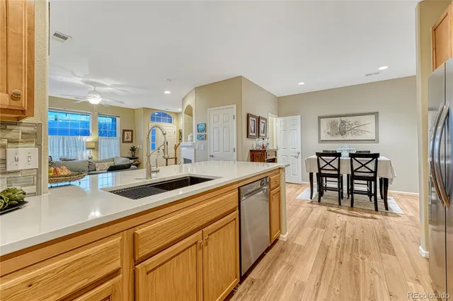 a kitchen with stainless steel appliances granite countertop a sink and wooden floors
