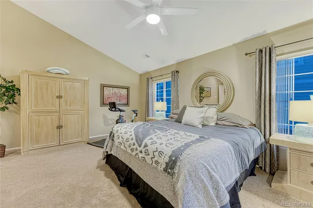 a bed sitting in a bedroom next to a window with tv and dresser