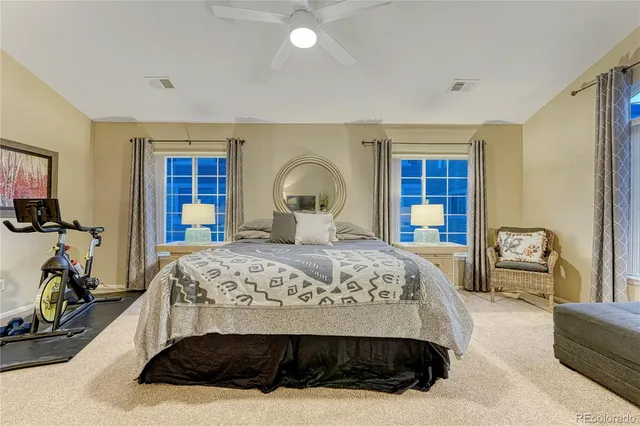 a bedroom with a large bed a flat tv screen and a chandelier
