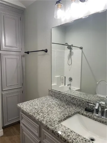 a bathroom with a granite countertop sink and vanity