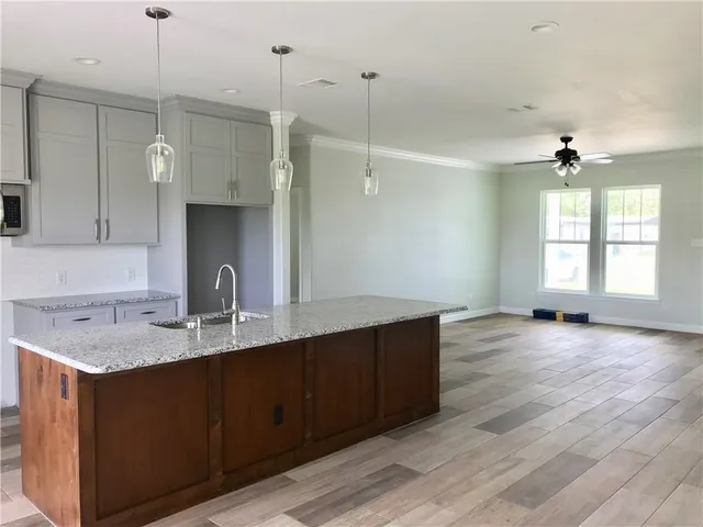 a kitchen with kitchen island a sink and wooden floor