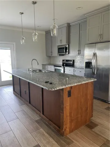 a kitchen with stainless steel appliances granite countertop a sink a counter space appliances and cabinets
