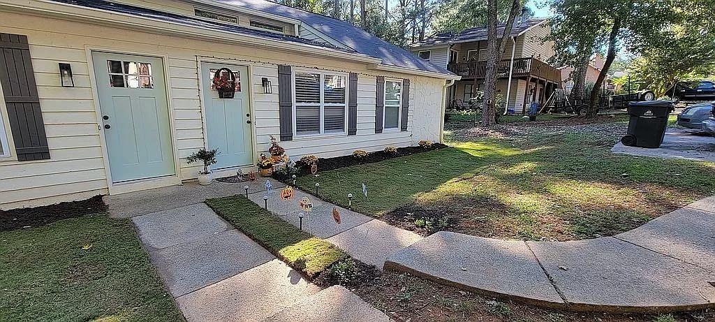 a view of a house with backyard and sitting area
