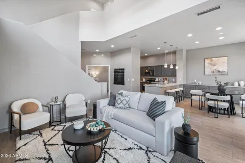 a living room with furniture a rug and kitchen view