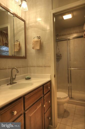 2711 Hunting Ridge Court Baldwin, MD 21013 - Photo 21 of 26 a bathroom with a granite countertop sink a toilet and shower