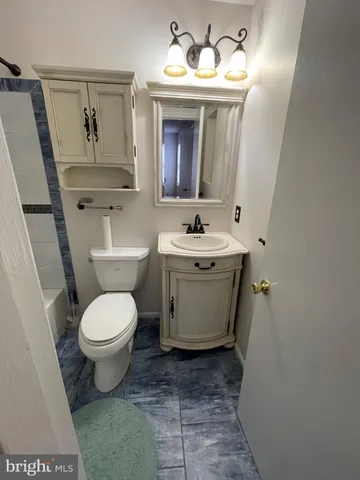 a spacious bathroom with a toilet sink and mirror