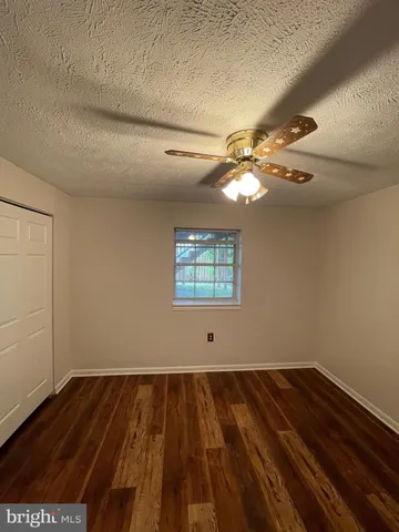 a view of a room with wooden floor and fan