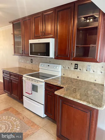 a kitchen with granite countertop wooden cabinets and stainless steel appliances