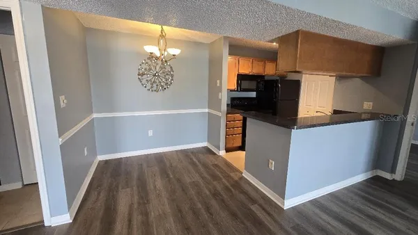 a kitchen with granite countertop a refrigerator a stove and wooden floor