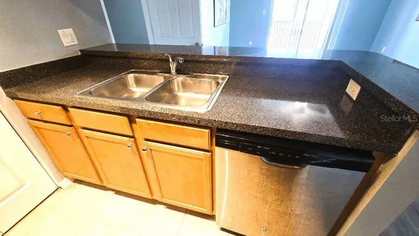 a kitchen with a sink a stove top oven and cabinetry