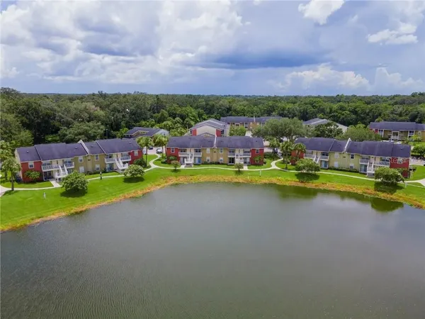 an aerial view of a house with a garden and lake view