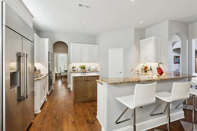 a kitchen with granite countertop a sink cabinets and stainless steel appliances