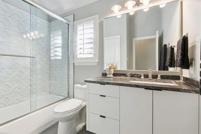 a bathroom with a double vanity sink toilet and shower
