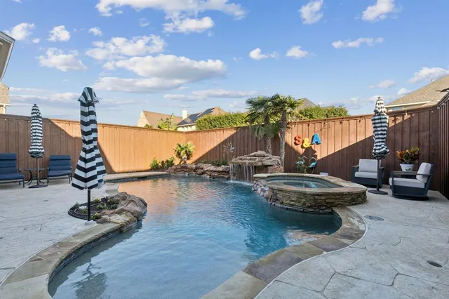 a view of a swimming pool with a patio and a yard