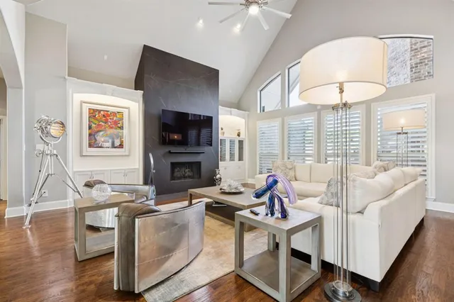 a living room with furniture a flat screen tv and a floor to ceiling window