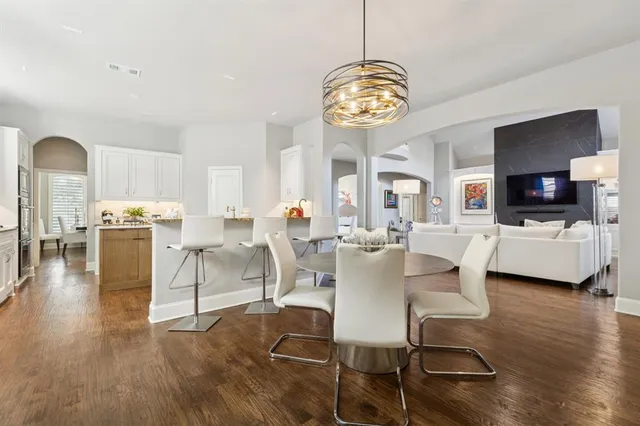 a view of a dining room with furniture a chandelier and wooden floor