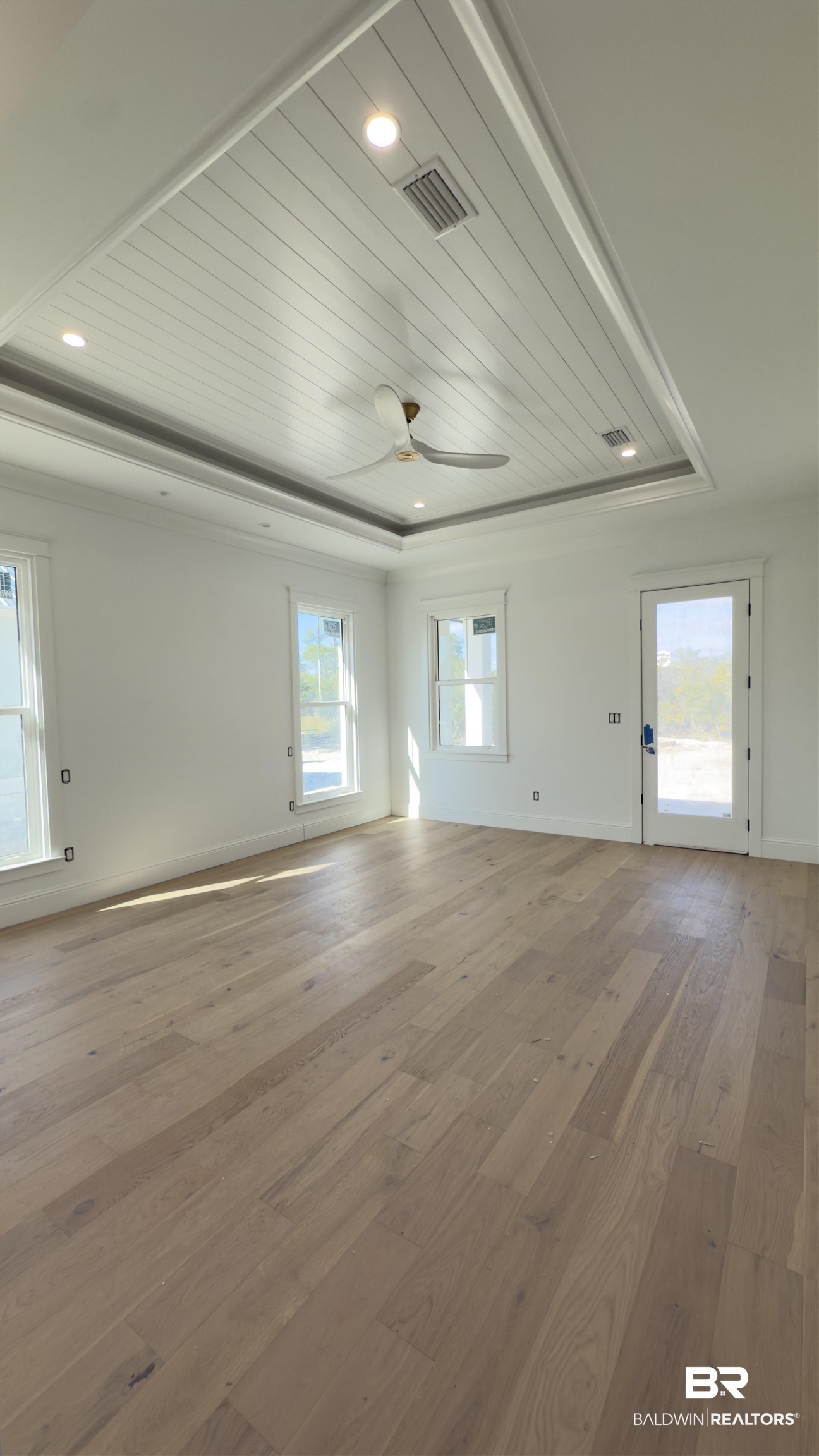 30327 River Road Orange Beach, AL 36561 - Photo 2 of 4 Unfurnished room with hardwood / wood-style flooring, ceiling fan, wood ceiling, and a tray ceiling