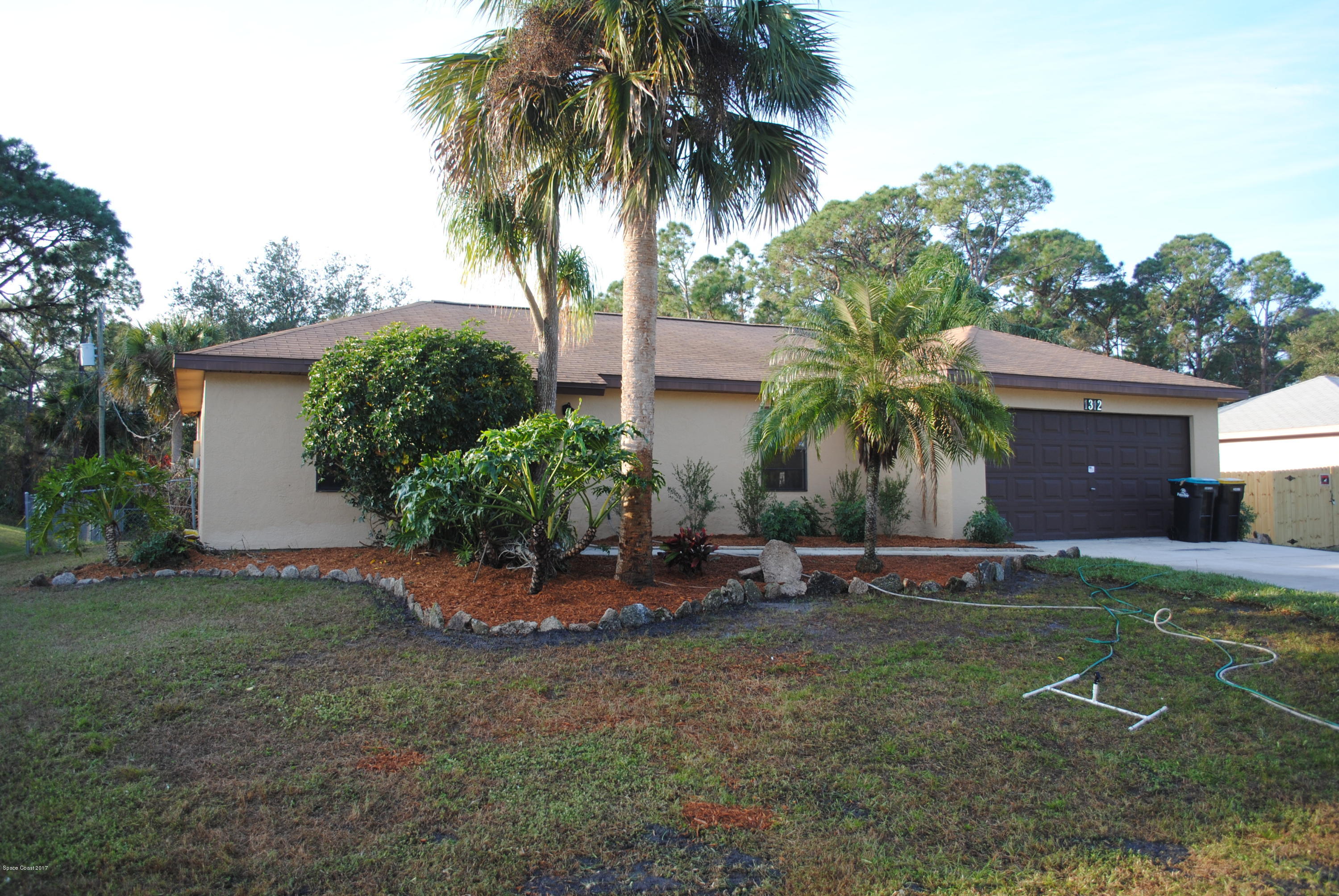 1312 Whitehurst Road Southwest Palm Bay, FL 32908 - Photo 1 of 35 a front view of a house with garden