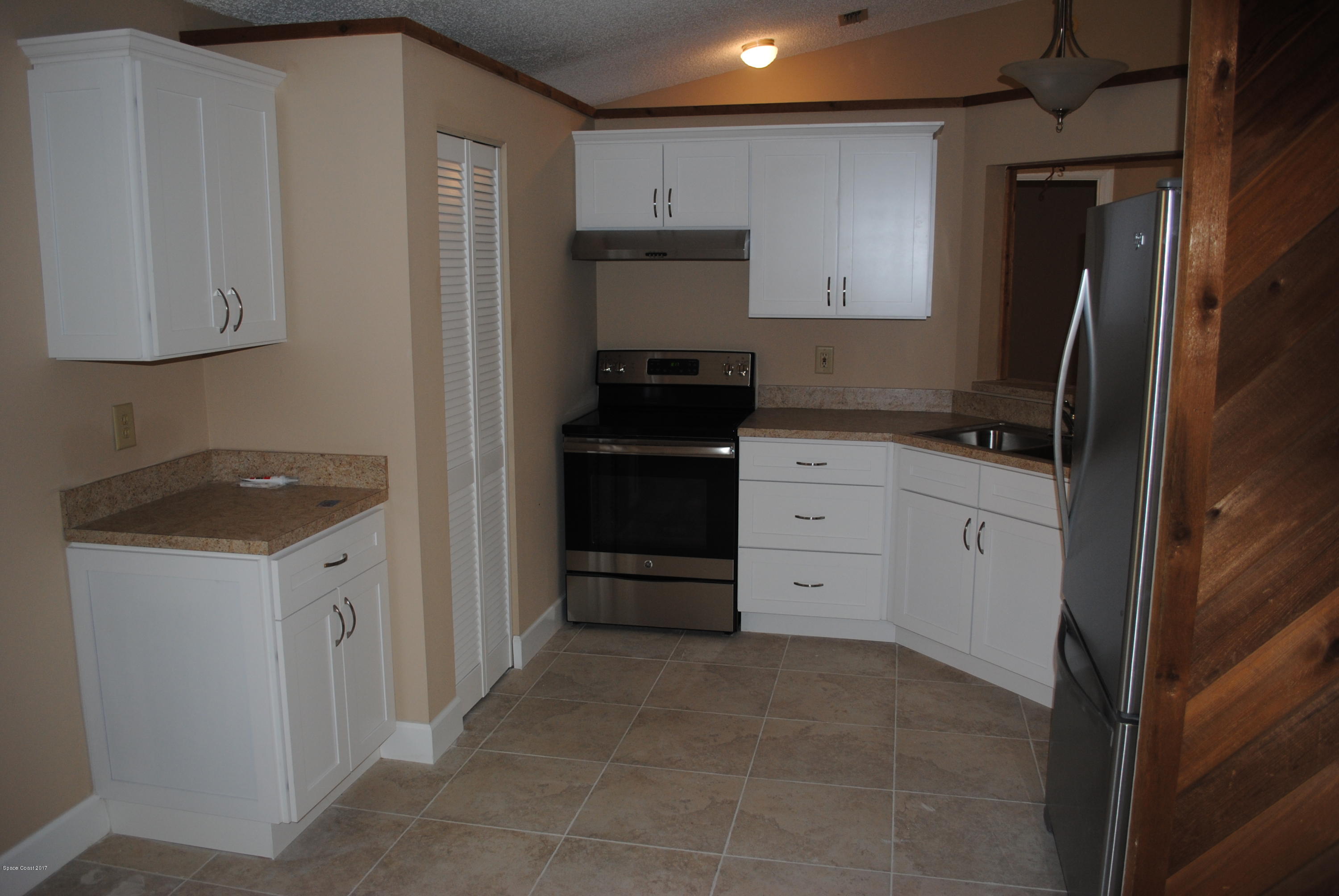 1312 Whitehurst Road Southwest Palm Bay, FL 32908 - Photo 9 of 35 a kitchen with granite countertop a refrigerator stove and sink