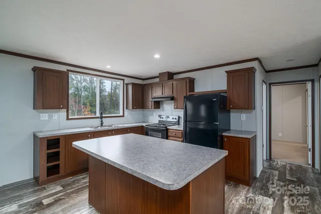 a kitchen with stainless steel appliances granite countertop a sink wooden cabinets and a granite counter tops