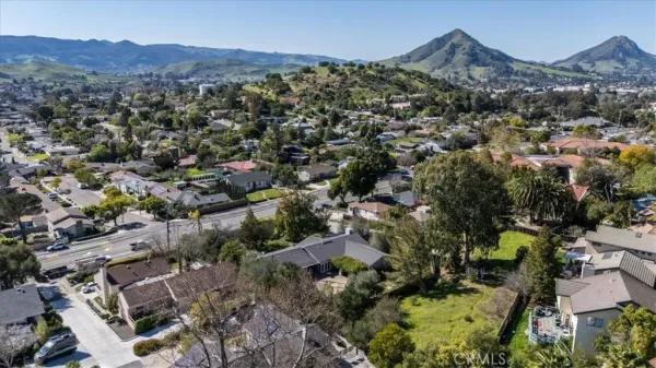 an aerial view of residential house with parking and covered mountain