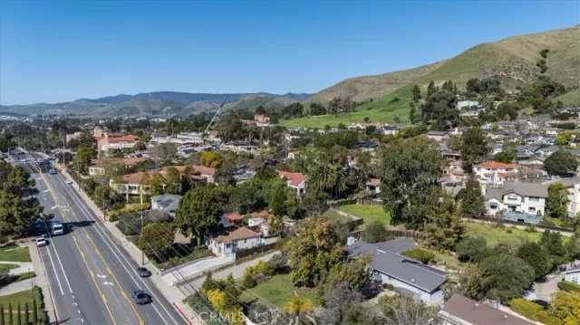 an aerial view of residential houses with outdoor space and trees