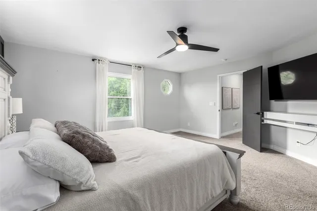 a large bedroom with a bed and a flat screen tv