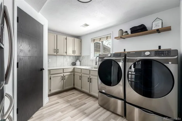 a kitchen with stainless steel appliances granite countertop a sink a stove a refrigerator and cabinets