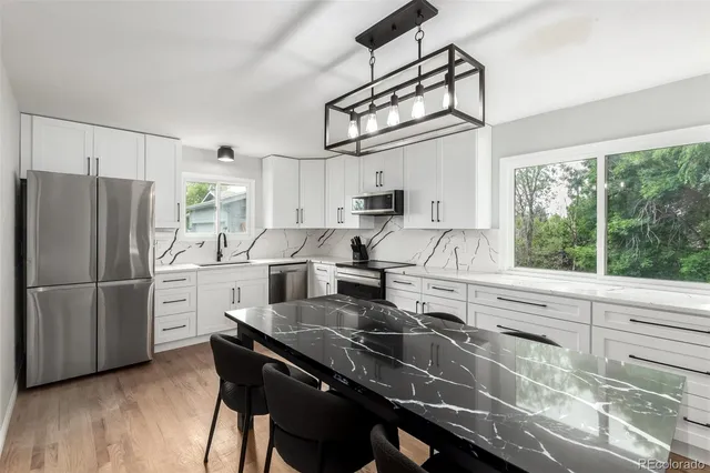 a kitchen with kitchen island a large counter top space appliances and cabinets