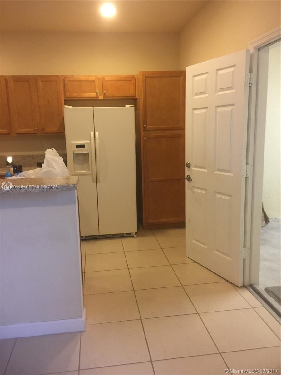 17059 Southwest 96th Street Miami, FL 33196 - Photo 5 of 22 a view of a refrigerator in kitchen and an empty room