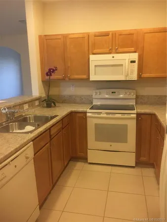 a kitchen with a stove top oven sink and cabinets