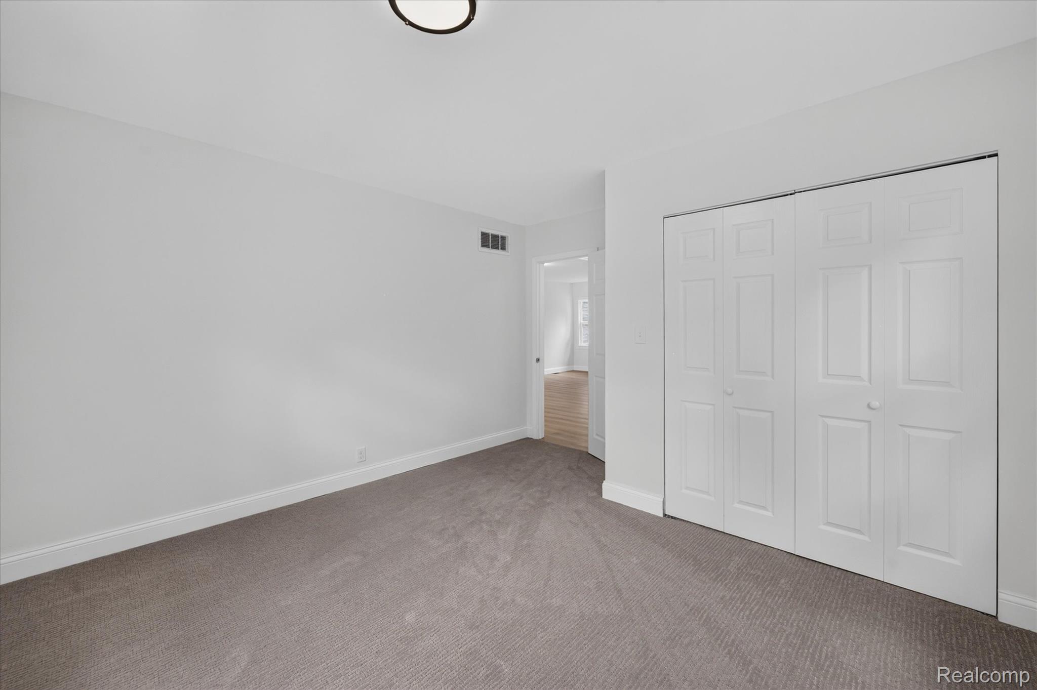 11403 White Lake Road Fenton, MI 48430 - Photo 21 of 36 Wall-to-wall carpeting with a neutral finish, white walls, white trim, and a ceiling-mounted light fixture