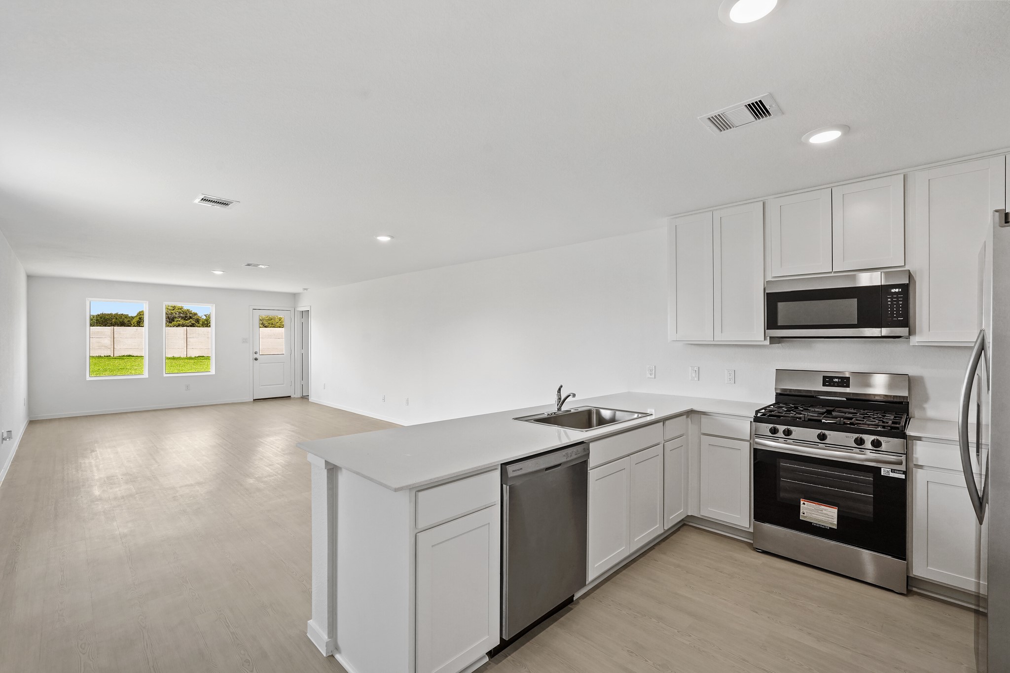 26931 Feather Reed Drive Katy, TX 77493 - Photo 5 of 16 This factual kitchen perspective details the deep undermount double sink, extensive counter space, and smooth vinyl plank flooring that extends into the main rooms.