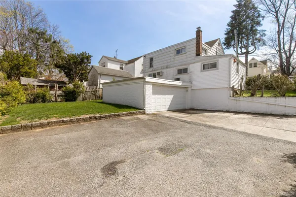 a view of a white house with a yard and garage
